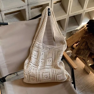 Detailed macro of beige crochet knit shoulder bag with hollow square pattern design