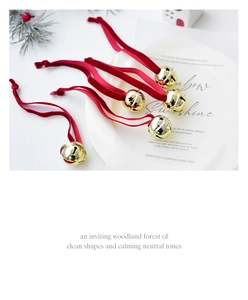 Macro shot of gold star-cutout metal bells with luxury red velvet ribbons for Xmas