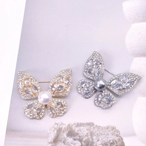 Broches papillon élégantes avec perles et zircons cubiques en finitions or et argent