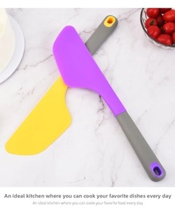 Detail of yellow and purple silicone spatulas for baking on marble background
