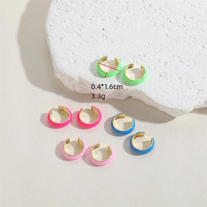 Colorful enamel C-shaped ear cuffs in neon green, blue, and pink on minimalist white stone