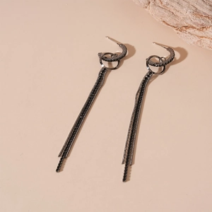 Macro shot of dark gunmetal chain earrings with black rhinestones and long tassels
