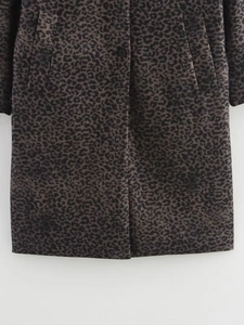 Detailed view of women's leopard print coat featuring classic patterns and button closure
