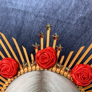 Detail of gold halo crown with deep red roses and golden stars on light blonde hair