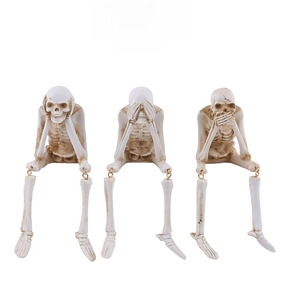Three skeleton figurines showing hear, see, and speak no evil with gold joint accents