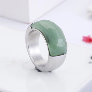 Macro shot of silver titanium wide ring with a green multifaceted gemstone inlay