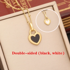 Double-sided heart pendant necklace in gold finish with black and white enamel details