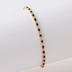 Details des Gold-Tennisarmbands mit abwechselnd blauen und weißen Zirkonia-Steinen