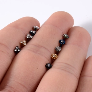 Clous d'oreilles fleur en acier inoxydable poli de diverses couleurs sur le bout des doigts