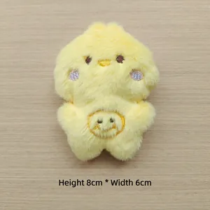 Detail of yellow plush chick doll with embroidered smile and 8cm by 6cm dimensions