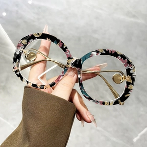 Retro oversized round sunglasses with floral frames and gold metal temples in hand