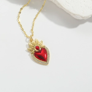 Detailed macro view of vintage heart pendant with red enamel and gold flame crown detail