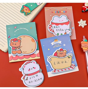 Detail of Christmas themed sticky notes featuring snowman and bear shapes on red background
