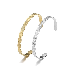 Detailed macro view of gold and silver hammered wavy open cuff bangles on white background