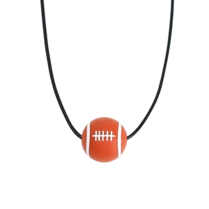 Macro shot of American football pendant with white stitching details on black cord