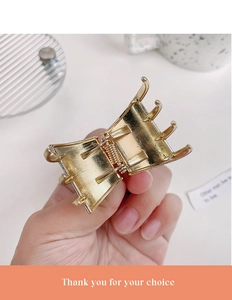 Close-up of golden metal hair claw clip with strong spring and polished finish