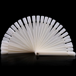 Fan-shaped white plastic nail swatches for polish display and art practice on black surface