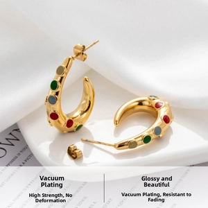 Detail of C-shaped gold earrings with colorful stones and vacuum plated glossy finish