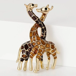 Detail of interlocking gold giraffe pins with brown enamel patterns and black diamond eyes