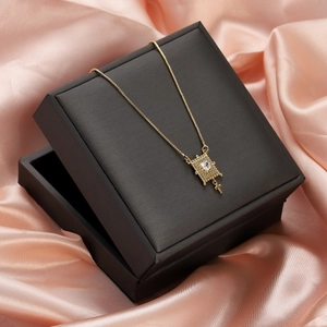 Detail of gold heart pendant necklace with cubic zirconia on black gift box over pink silk