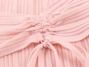 Detail of elegant pink chiffon dress with pleated fabric and delicate bow tie closure