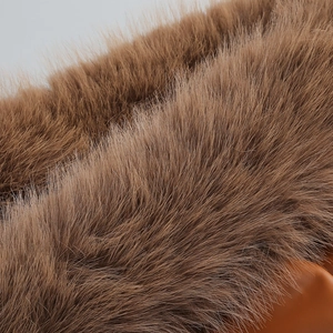 Vue détaillée de la texture du col en fourrure marron foncé sur une robe élégante