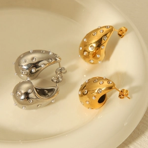 Polished stainless steel water drop earrings with pearls and rhinestones on a ceramic tray