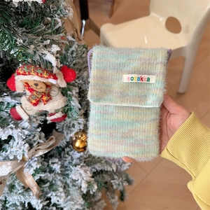 Detail of colorful fluffy plush phone bag with knit texture and vibrant sozakka label