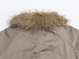 Detail of faux fur collar and plaid fabric texture on a double-sided trench coat
