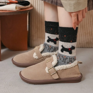 Detail of wool socks with dog pattern paired with fleece-lined khaki winter shoes