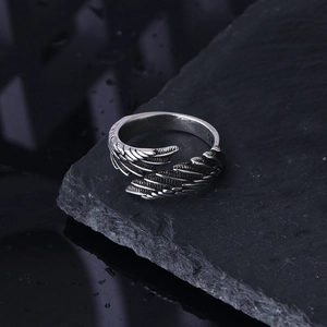 Detailed close-up of retro silver angel wing ring with S925 engraved on black stone base