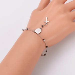Silver stainless steel rosary bracelet with black faceted beads and cross pendant on hand
