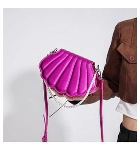 Detail der magenta schalenförmigen Umhängetasche mit Perlenkette und Steppmuster