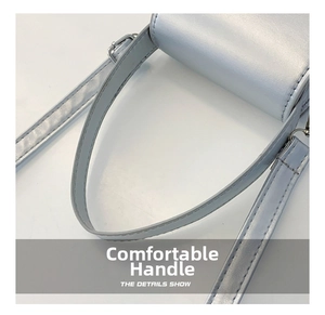 Detail of light blue faux leather handbag featuring metal buckle and adjustable shoulder strap