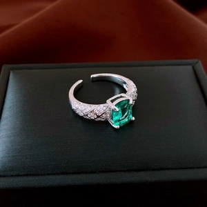 Vista dettagliata dell'anello verde smeraldo con motivo a rombi su portagioie nero