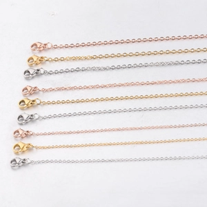 Detail showing various stainless steel chain necklaces in gold, silver, and rose gold finishes