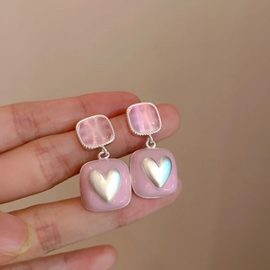 Dettaglio orecchini rosa in resina con cuori in argento e finitura lucida e rifinita