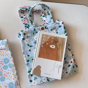 Close-up of floral canvas tote bag with light blue print and metal snap button