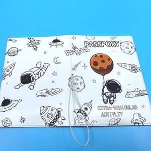 Close-up of white passport holder featuring cartoon astronaut and space themed line art