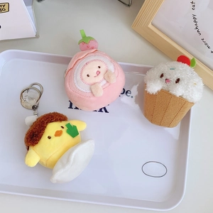 Cute plush strawberry cake and pudding keychain charms displayed on a white tray