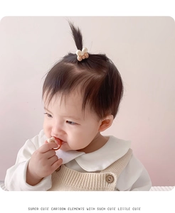 Close-up of a child wearing a cute cream and brown cartoon rabbit hair clip