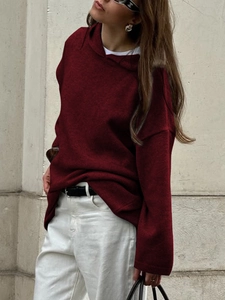 Street style view of wine red knitted hoodie showing loose fit and soft fabric texture