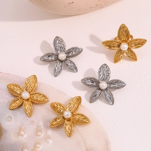 Detail of flower stud earrings with brushed texture finish and centered pearls