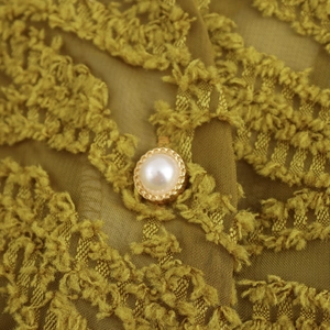Women's V-neck textured shirt in ginger yellow with lantern sleeves and pearl button detail