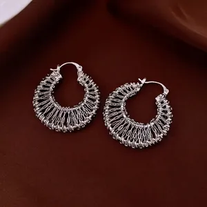 Luxury silver woven hollow hoop earrings with textured chain link design on velvet