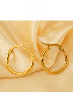 Macro shot of 18K gold plated spiral hoop earrings with lever back on silk texture