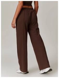 Detail of high-waist dark brown wide-leg sweatpants featuring vertical seam and elastic waist