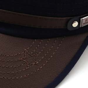 Macro shot of navy twill fabric and brown leather brim with star embroidery and metal rivet