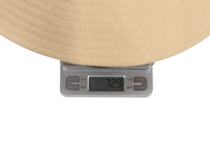 Detail shot of lightweight sun hat weighing 72.9g on digital scale showing precise stitching