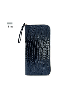 Detalle de cartera larga azul con patrón de cocodrilo, cremallera dorada y correa de mano